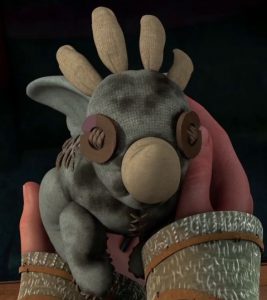 Hiccup holding his childhood toy that his mother had made for him when he was a baby.