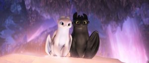 Light Fury and Toothless sitting next to each other inside the Hidden World