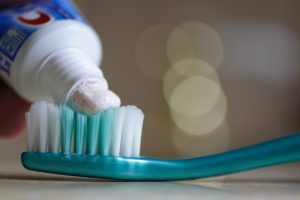 Toothpaste being placed onto toothbrush