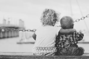 A young child putting arms around another child