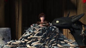 Hiccup almost completely buried in fish, and Toothless looking at him smugly.