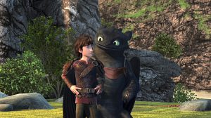 Hiccup and Toothless both standing on 2 feet and looking at each other.