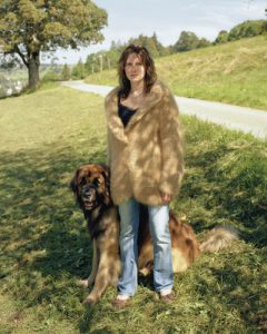 Woman with her tan dog hair cardigan, and her Leonberger dog