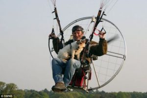 Man paragliding, with dog