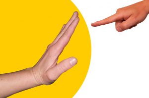 Human hand on left with open palm, smaller human hand on right pointing towards left